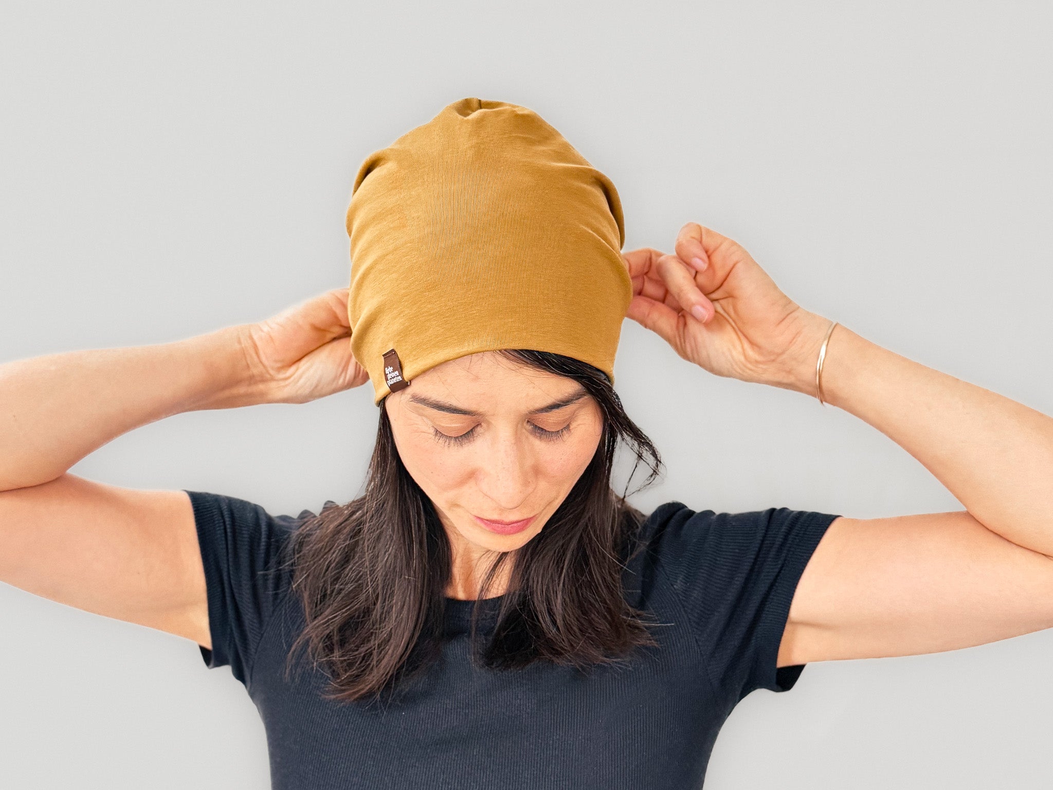 Frau mit dunklem Haar sezuz karamellfarbene Mütze auf 