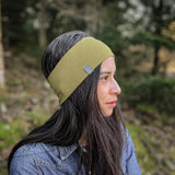 BAsic Sportstirnband in pistaziengrün aus 100% Biobaumwolle, Frau mit langen dunkelbraunen Haaren und Jeanshemd im Wald,